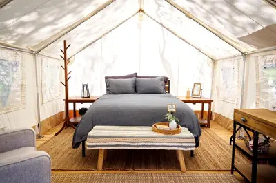 a bedroom with a bed in a greenhouse at Safari Tents for Romantic Escapes in California's El Dorado County in Pilot Hill