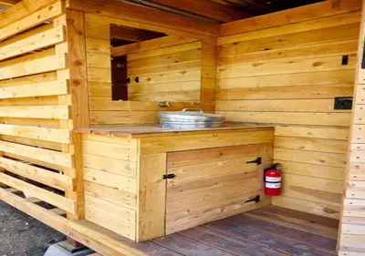 a wooden sauna with a sink and a fire extinguisher at Safari Tents for Romantic Escapes in California's El Dorado County in Pilot Hill