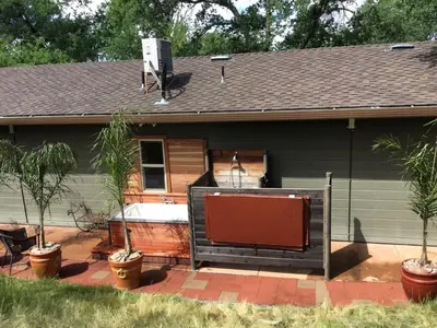 a house with a hot tub in the backyard at Quiet Cottage Rental for Two in Horse Country near Yosemite National Park Gateway, California in Catheys Valley