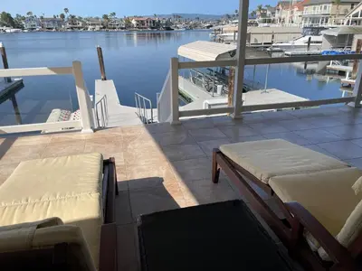 a balcony with two beds and a view of a marina at Discovery Bay Home on fast water - 2,400Sq ft in Discovery Bay