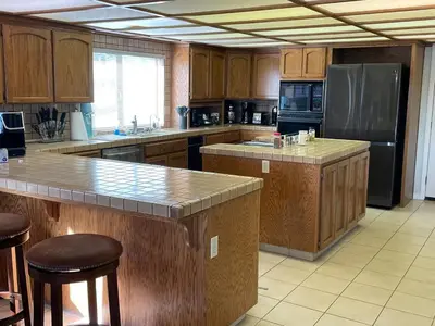 a large kitchen with wooden cabinets and stainless steel appliances at Discovery Bay Home on fast water - 2,400Sq ft in Discovery Bay
