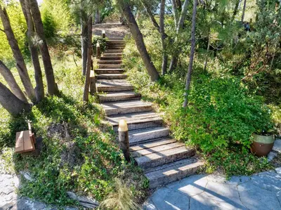 a set of wooden stairs in the grass with trees at Spacious Mountain View Home - Pool, Spa & Game Rm in Oakhurst