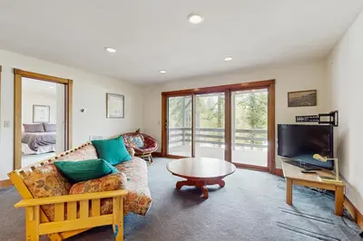 a living room with a couch and a table and a tv at Peace and Pines at Upper Ward Creek in Tahoe City
