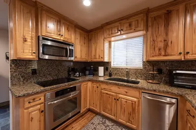 a kitchen with wooden cabinets and stainless steel appliances at Charming and Relaxing Getaway with Great Views in Shaver Lake