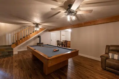 a pool table in a living room with a ceiling fan at Charming and Relaxing Getaway with Great Views in Shaver Lake