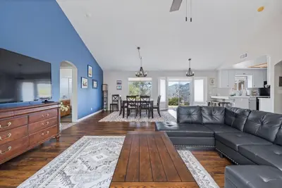 a living room with a black couch and a kitchen at Sunset Lookout Mountain villa, Meadows, Gazebo in Coarsegold