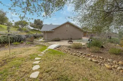 a backyard with a house and a yard with rocks at Sunset Lookout Mountain villa, Meadows, Gazebo in Coarsegold
