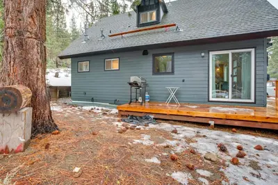 a house with a wooden deck next to a tree at Backyard Forest Retreat in South Lake Tahoe