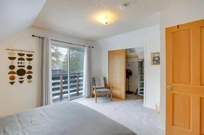 a bedroom with a bed and a window and a chair at Backyard Forest Retreat in South Lake Tahoe