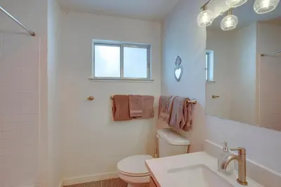 a bathroom with a toilet and a sink and a mirror at Backyard Forest Retreat in South Lake Tahoe