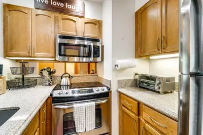 a kitchen with wooden cabinets and a stove top oven at Hike, Sled and Ski! Cozy Tahoe City Condo with Hot Tub in Tahoe City