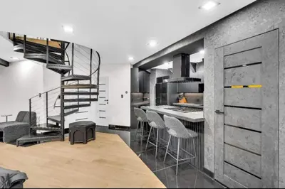 a kitchen with a spiral staircase and a bar with stools at Modern Mountain Luxury Soak, Stay, & Be Spoiled in Shaver Lake
