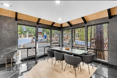 a dining room with a table and chairs and large windows at Modern Mountain Luxury Soak, Stay, & Be Spoiled in Shaver Lake