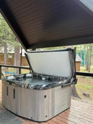a hot tub sitting on top of a wooden deck at Modern Mountain Luxury Soak, Stay, & Be Spoiled in Shaver Lake