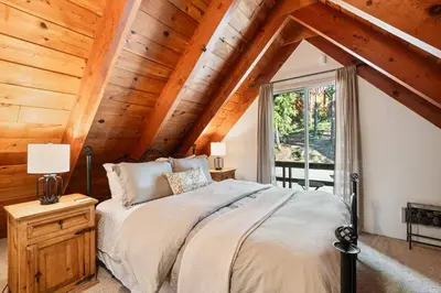 a bedroom with a bed in a room with wooden ceilings at Piece of Paradise Dream Deck AC in Shaver Lake