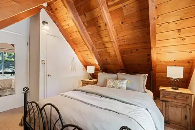 a bedroom with a bed in a room with wooden ceilings at Piece of Paradise Dream Deck AC in Shaver Lake