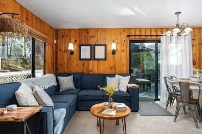 a living room with a blue couch and a table at Piece of Paradise Dream Deck AC in Shaver Lake