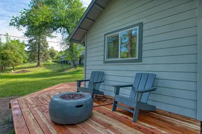 two blue chairs sitting on a deck next to a house at The Mountains are Calling - Private, Guesthouse Retreat near Yosemite in Ahwahnee
