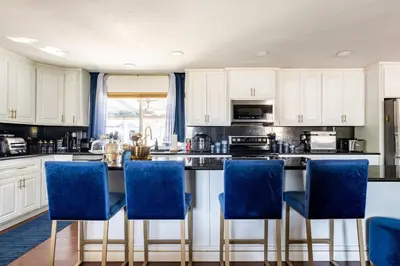 a kitchen with white cabinets and blue chairs at Memorable Moment at Placid Blue with Pool & Hot Tub in Sacramento