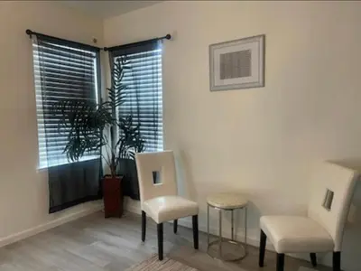 a room with two chairs and a plant and a window at Spacious 4 bedroom house! in Stockton
