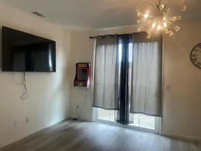 a living room with a television and a window at Spacious 4 bedroom house! in Stockton