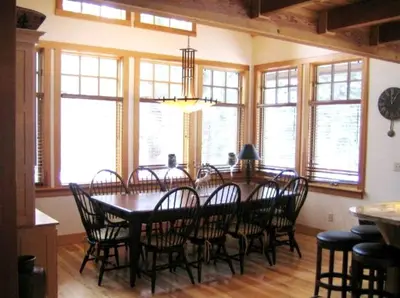 a dining room with a table and chairs and windows at Modern Woodland Cabin Getaway with a Fireplace in Truckee, California in Truckee