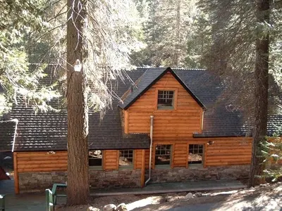a log cabin in the middle of the woods at Spacious Riverfront Cabin Rental Perfect for Large Groups near Sonora, California in Strawberry