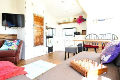 a living room with a couch and a chess board at Rustic Trailer Rental on the Shores of Bridgeport Reservoir, California in Bridgeport