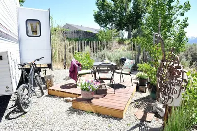 a patio with a table and a bike in a yard at Rustic Trailer Rental on the Shores of Bridgeport Reservoir, California in Bridgeport
