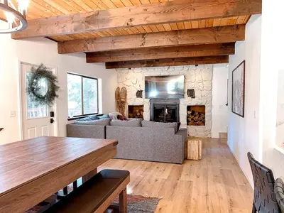 a living room with a couch and a stone fireplace at Fabulous Glamping Spot in Truckee, California: Charming Cabin near Lake Donner in Truckee