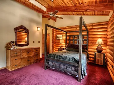 a bedroom with a bed and a dresser and a mirror at Cozy Log Cabin near Yosemite National Park in California in Mariposa