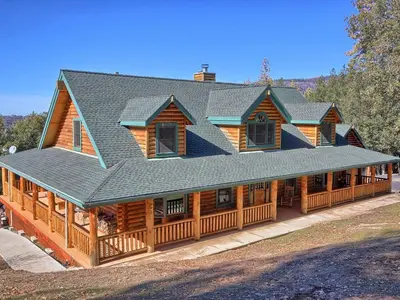 a large wooden house with a gambrel roof at Exceptionally Spacious Log Cabin for Groups in Mariposa, California in Mariposa
