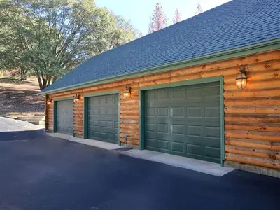 two garage doors on the side of a house at Exceptionally Spacious Log Cabin for Groups in Mariposa, California in Mariposa