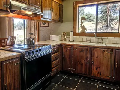 a kitchen with wooden cabinets and a black stove top oven at Family-Friendly Cabin near Yosemite National Park in California in Mariposa