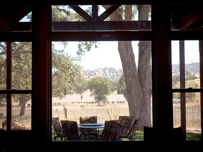 a view of a table and chairs from a window at Exquisite Cottage Rental on Peaceful Vineyard near Bear Valley, California in Angels Camp
