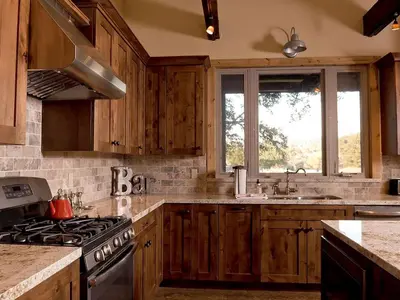 a kitchen with wooden cabinets and a stove top oven at Exquisite Cottage Rental on Peaceful Vineyard near Bear Valley, California in Angels Camp