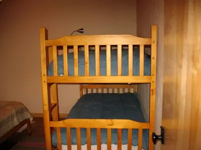 a wooden bunk bed with a green mattress on it at Exceptional Riverside Cabin Rental in the Trees near Pinecrest Lake, California in Strawberry
