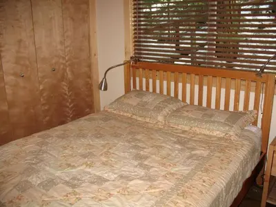a bedroom with a bed with a window and a bed sidx sidx sidx at Exceptional Riverside Cabin Rental in the Trees near Pinecrest Lake, California in Strawberry