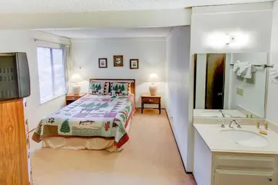 a bedroom with a bed and a bathroom with a sink at Sherwin Villas Free Shuttle & Near Skiing in Mammoth Lakes