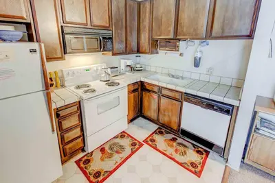 a kitchen with white appliances and wooden cabinets at Sherwin Villas #63 Private Deck & Near Lakes in Mammoth Lakes