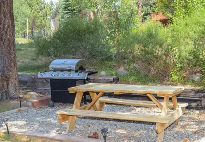 a picnic table and a grill in a yard at Aspen Creek #113 Family Friendly Condo in Mammoth Lakes