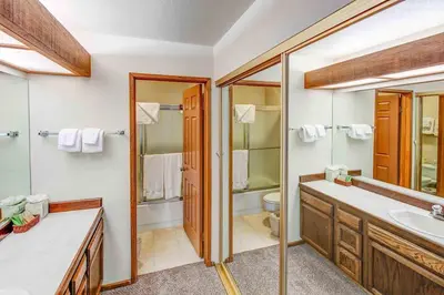 a bathroom with a sink and a toilet and a mirror at Aspen Creek #113 Family Friendly Condo in Mammoth Lakes