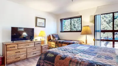 a bedroom with two beds and a flat screen tv at Aspen Creek #215 Hot Tubs Near Golf & Hiking in Mammoth Lakes