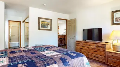 a bedroom with a bed and a flat screen tv at Aspen Creek #215 Hot Tubs Near Golf & Hiking in Mammoth Lakes