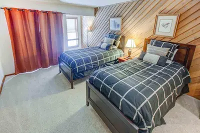 two beds in a room with wood paneling at Aspen Creek #225 Hot Tub & Pool Near Skiing in Mammoth Lakes