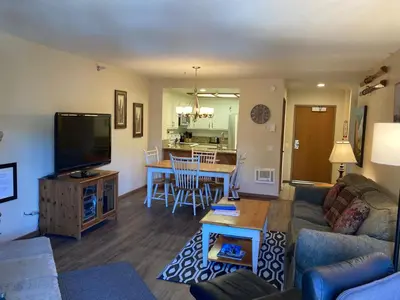 a living room with a couch and a tv and a table at Aspen Creek #226 Year-Round Activities in Mammoth Lakes