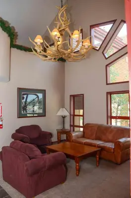 a living room with leather furniture and a chandelier at Aspen Creek #226 Year-Round Activities in Mammoth Lakes