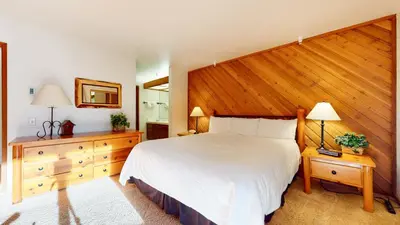 a bedroom with a large bed with a wooden headboard at Aspen Creek Shared Amenities Near Hiking in Mammoth Lakes