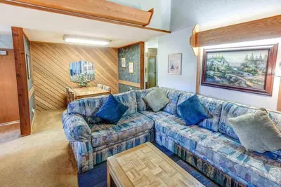 a living room with a blue couch and a table at Aspen Creek #401 Year-Round Outdoor Activities in Mammoth Lakes