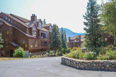 a large house with a stone wall in front of a street at Aspen Creek #401 Year-Round Outdoor Activities in Mammoth Lakes